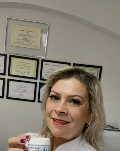 Elaine de Araújo no consultório, com certificados na parede